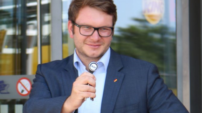 Marian Wendt, MdB, zeigt den Kontrolltransponder, der seine Anwesenheit am Bahnhof zusätzlich überwacht